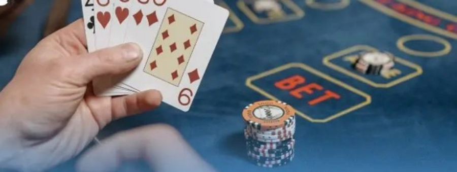 Tay người chơi cầm bài và đặt chip vào ô Bet trên bàn casino