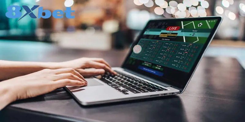 Người chơi theo dõi bảng kèo trên máy tính xách tay trước giờ bóng lăn